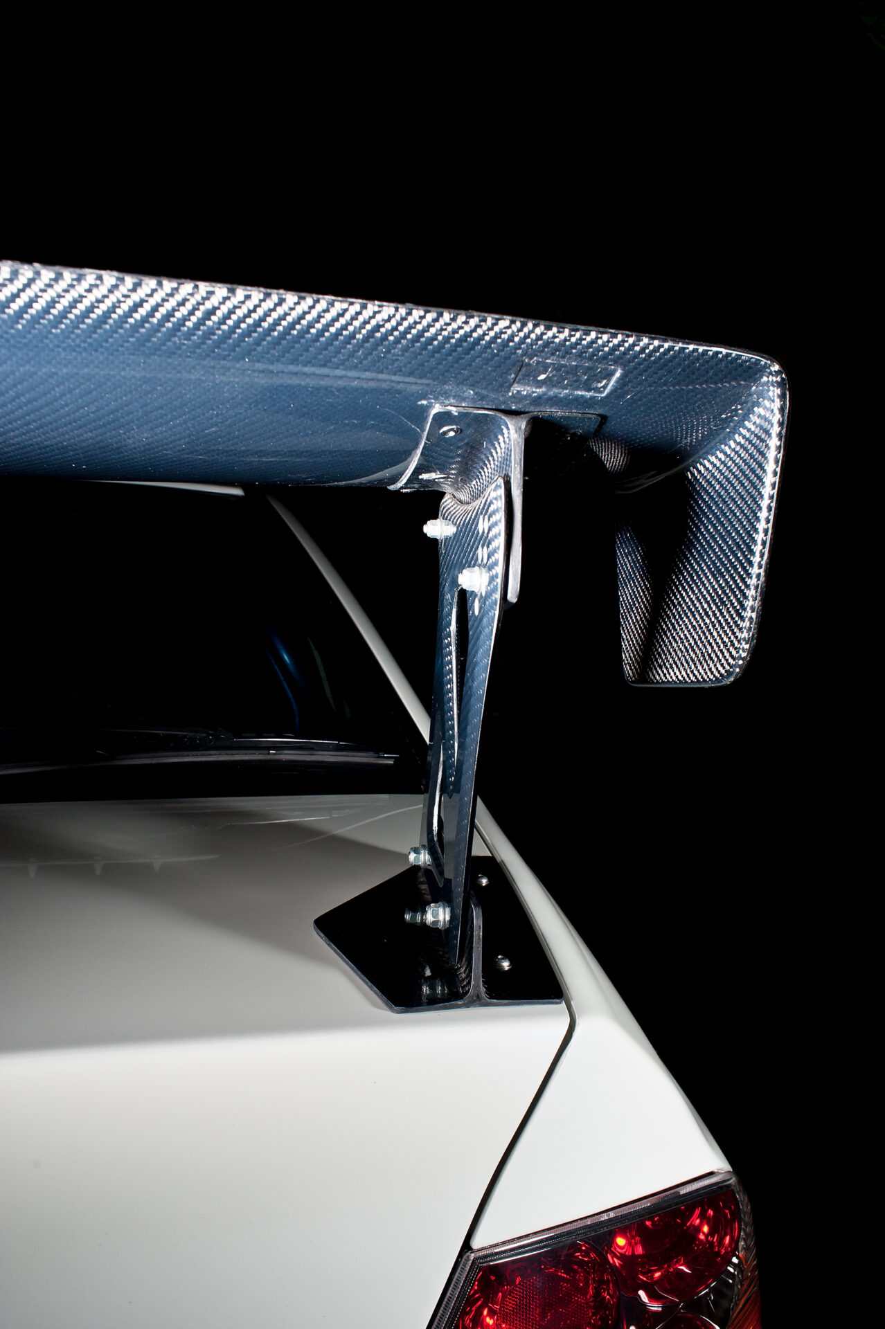 Rear carbon fiber wing shot of White Mitsubishi Evo IX with Varis body kit