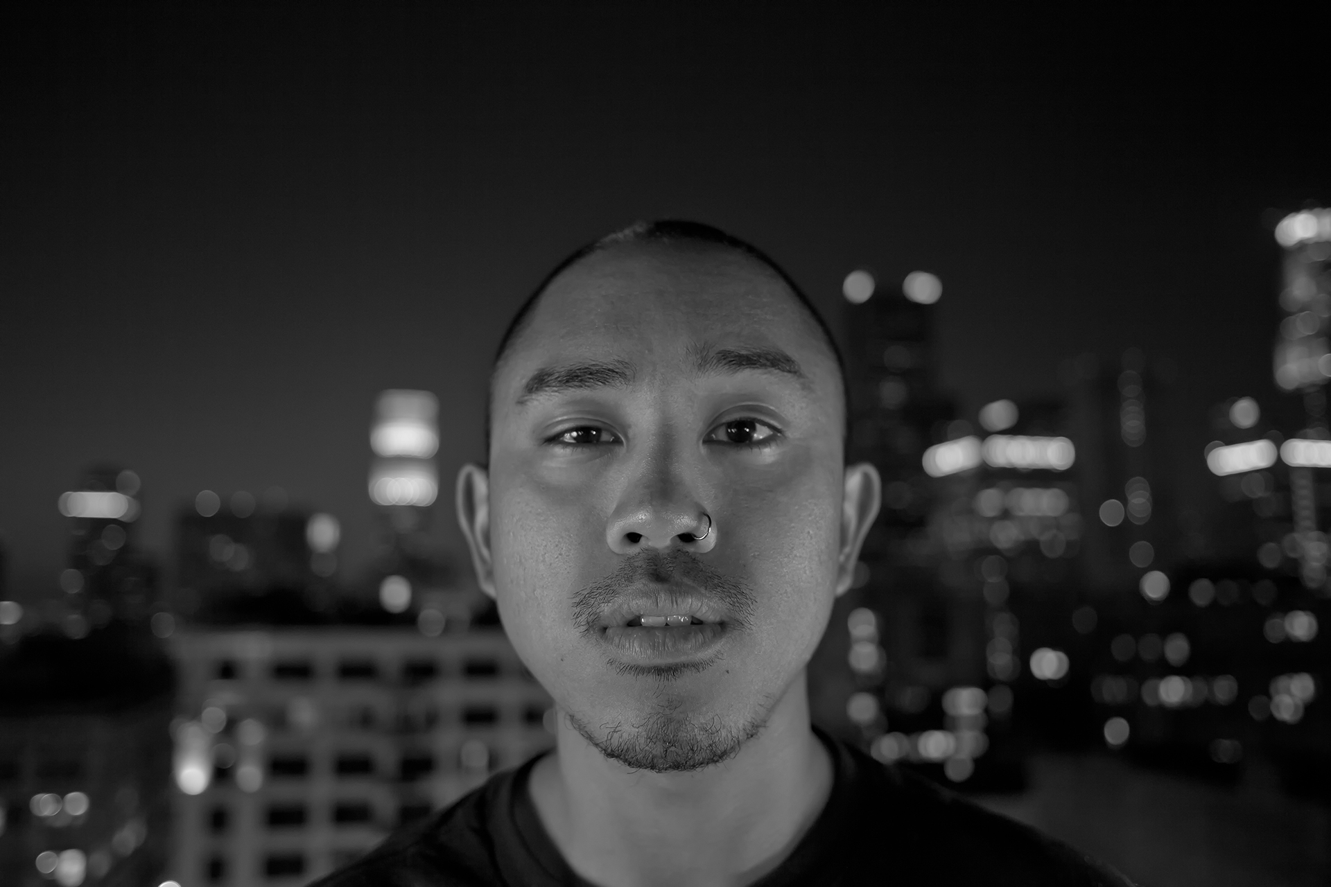 Josh stares into the camera with downtown Los Angeles twinkling behind him