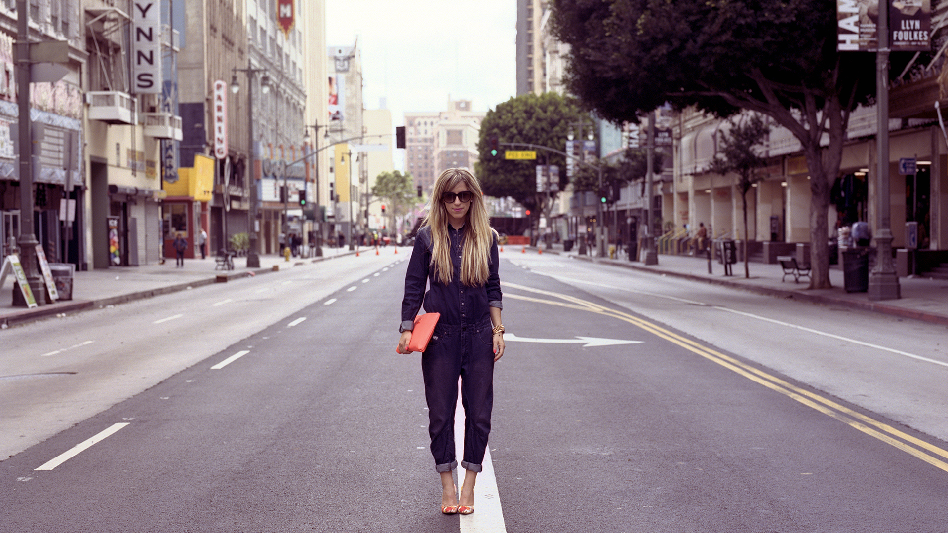 Kristen stands in the middle of Broadway Ave in downtown Los Angeles