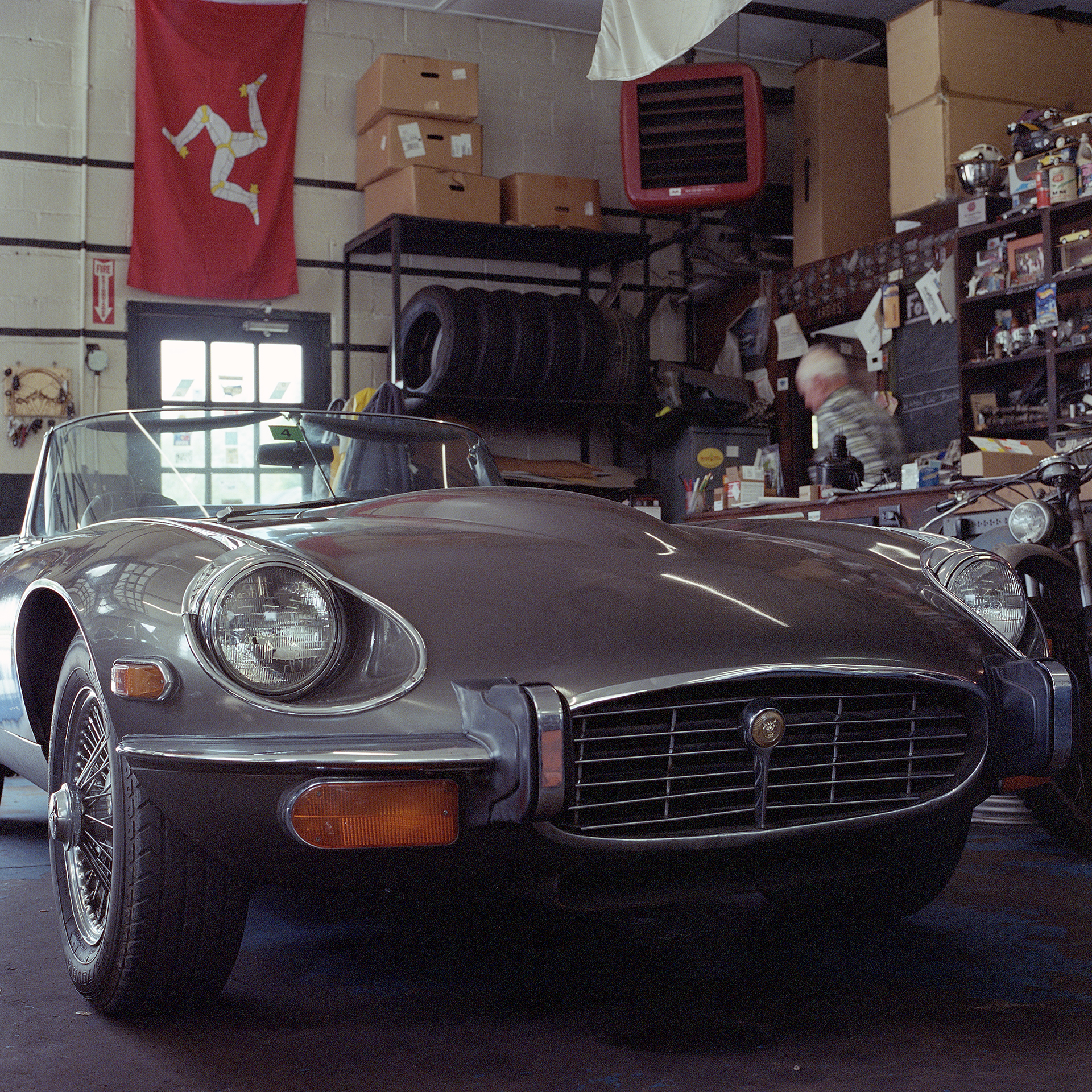 Color photo of low angle shot of grey Jaguar E-Type and Ava Restoration Services